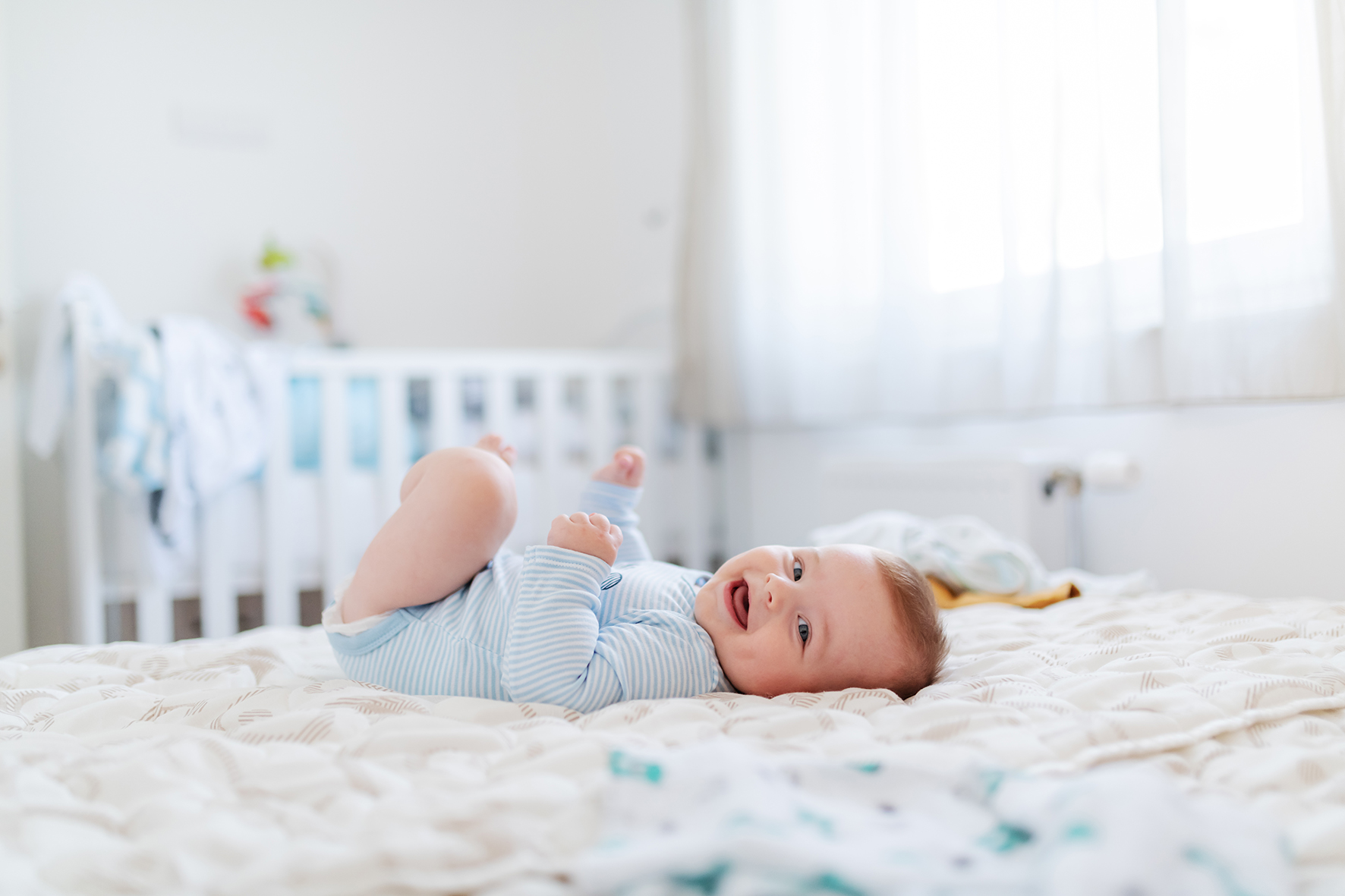 Side view of adorable chubby six months old baby boy lying on be